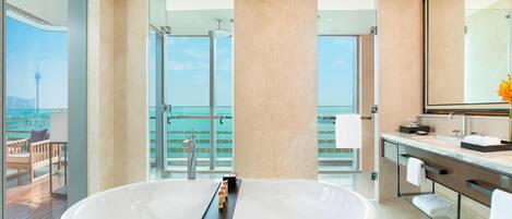 A modern bathroom with a large bathtub, a glass-enclosed shower, and a vanity with a mirror.