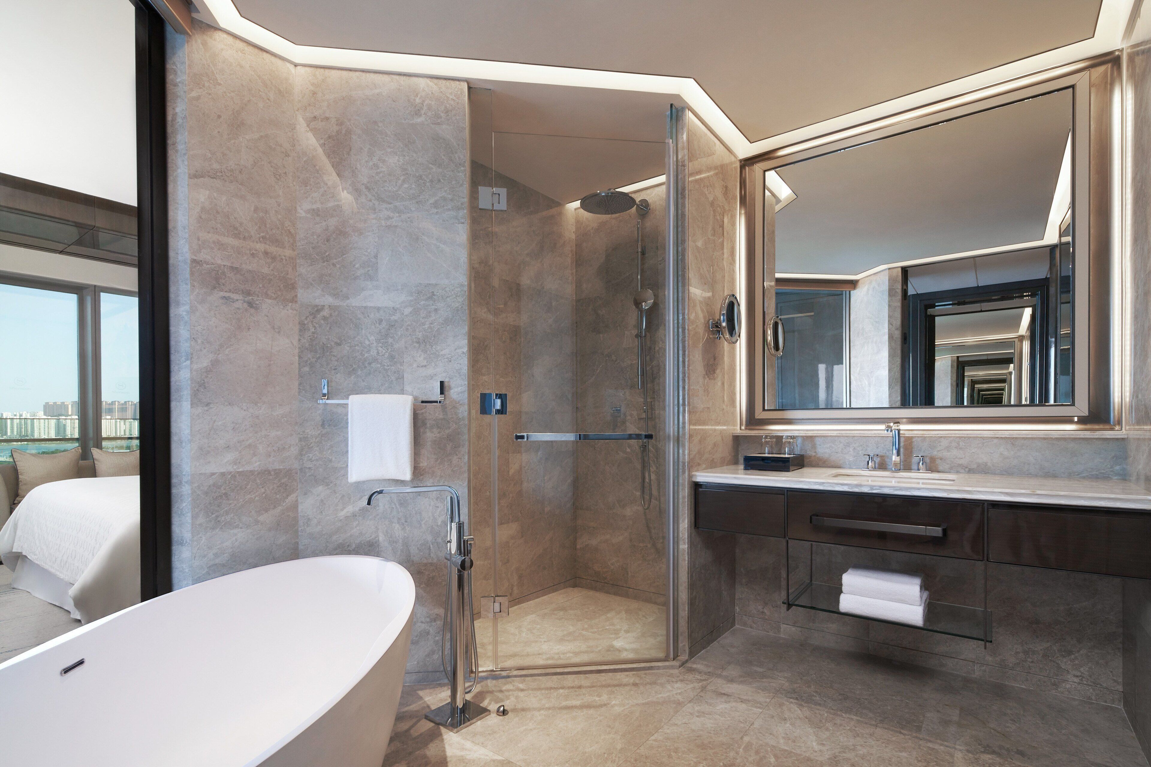 Ein modernes Badezimmer mit einer Duschkabine, einem großen Spiegel und einer Badewanne.