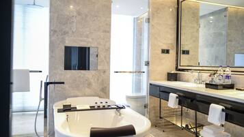A modern bathroom with a freestanding bathtub, a large mirror, and a glass-enclosed shower.