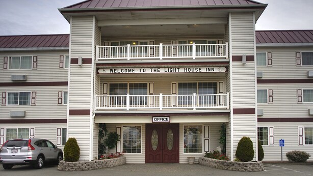 A two-story building with a sign reading "Welcome to the Light House Inn" and an "Office" sign below the entrance. - Lighthouse Inn (Crescent City)