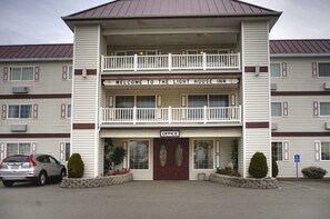 Un edificio de dos pisos con un cartel que dice "Welcome to the Light House Inn" y un letrero de "Oficina" debajo de la entrada.