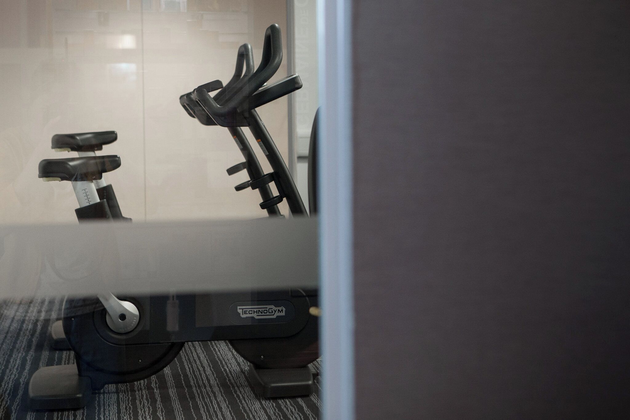 A stationary exercise bike with a digital display and a weight stack.