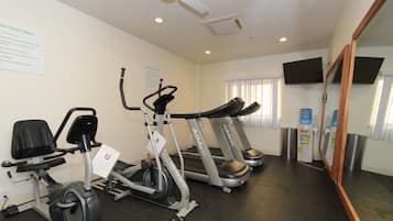 Un centre de remise en forme équipé de tapis de course, d’un vélo elliptique et d’un vélo d’appartement.