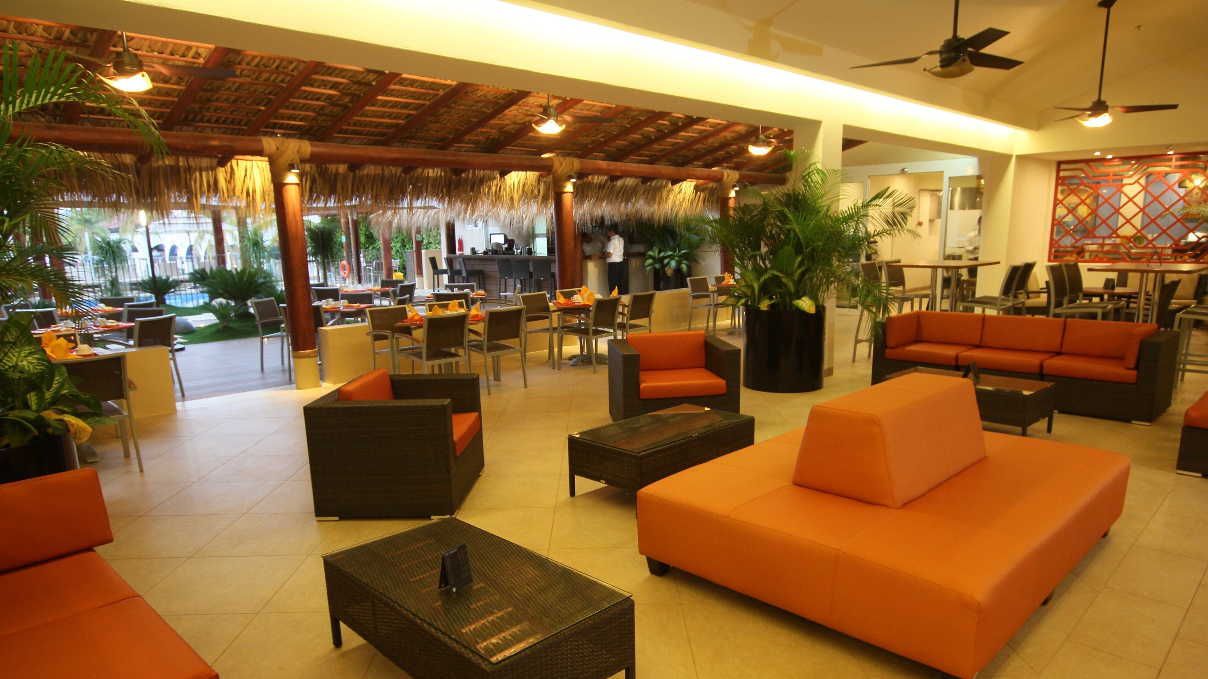 A spacious indoor area with seating arrangements, a ceiling fan, and a bar area.