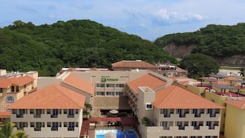 Un hotel con varias construcciones, una piscina y un paisaje montañoso.