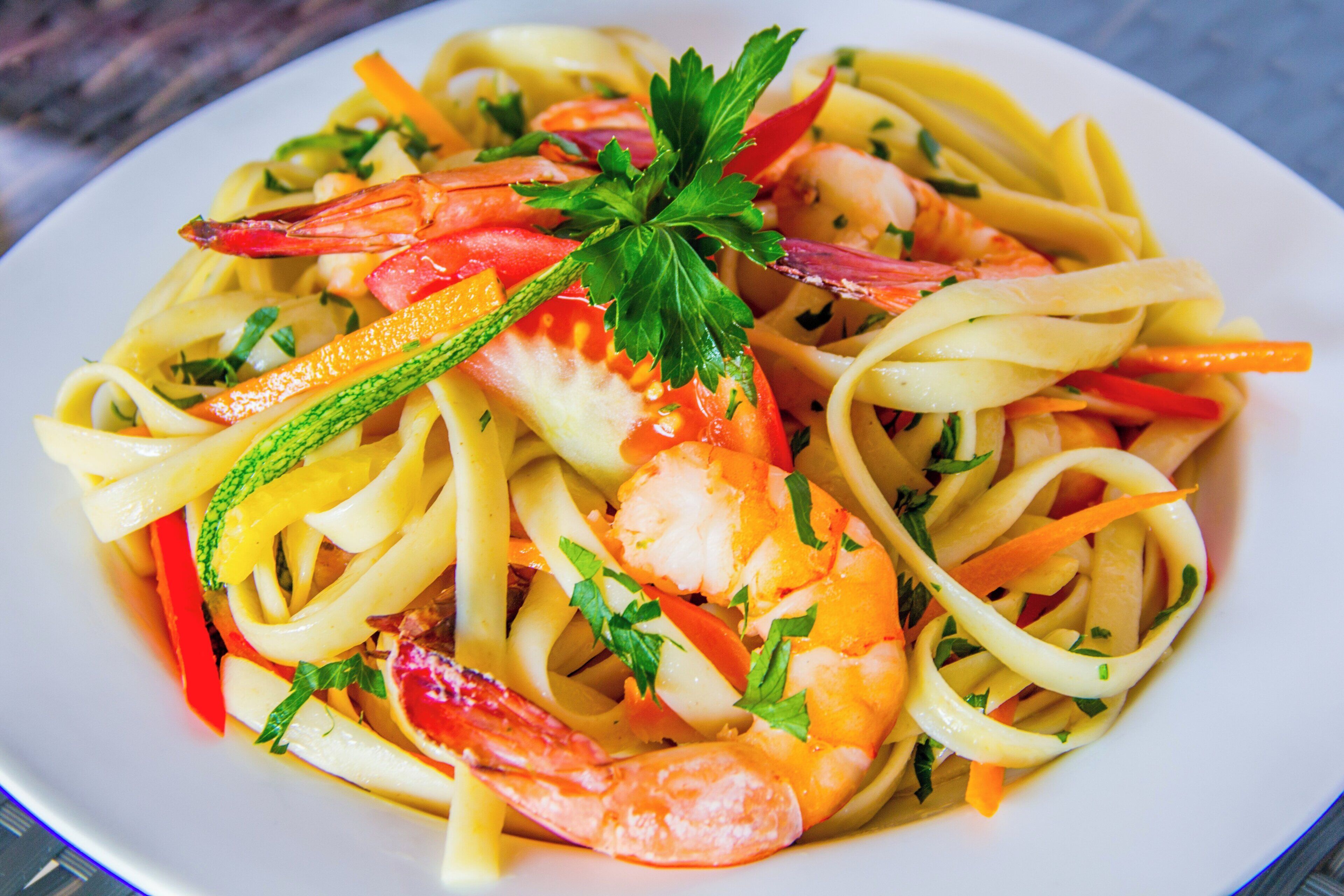 Eine Pasta-Platte mit Garnelen und Gemüse.