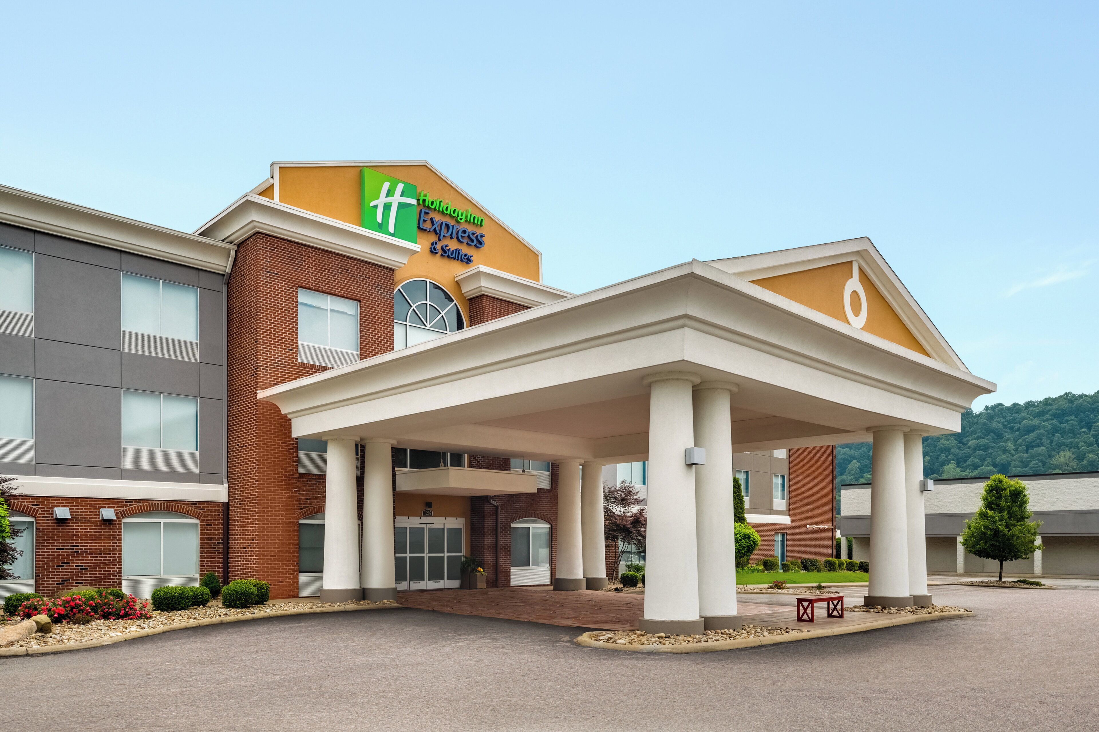 A Holiday Inn Express & Suites building with a covered entrance and a brick facade.