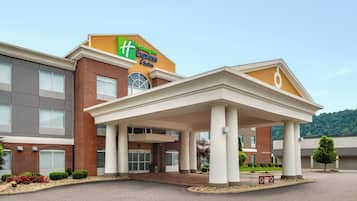A Holiday Inn Express & Suites building with a covered entrance and a brick facade.