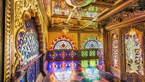 Un interior ornamentado con vidrieras elaboradas y detalles en madera.