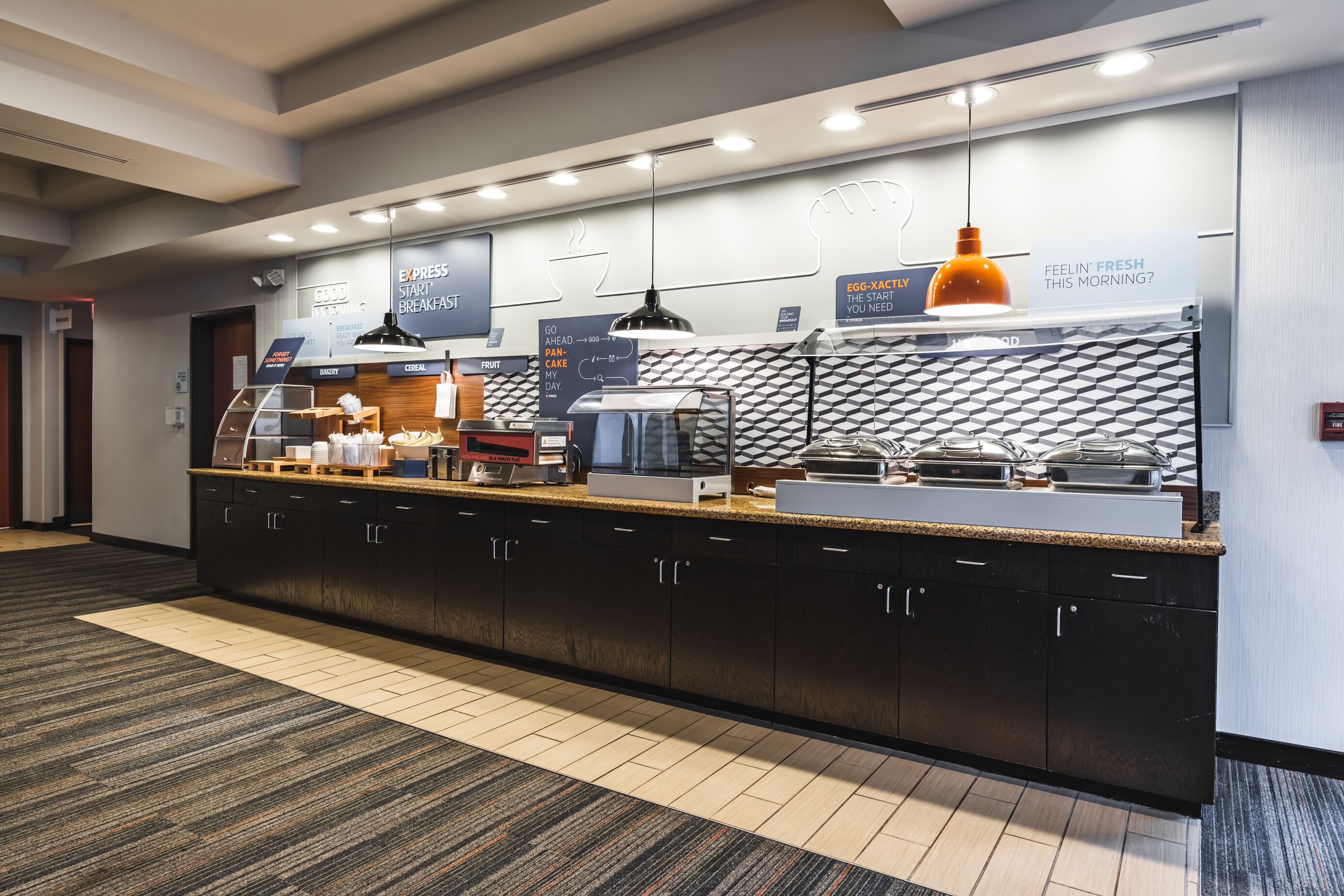 A modern breakfast bar with a variety of food options, including cereal and coffee.