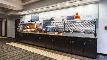 A modern breakfast bar with a variety of food options, including cereal and coffee.