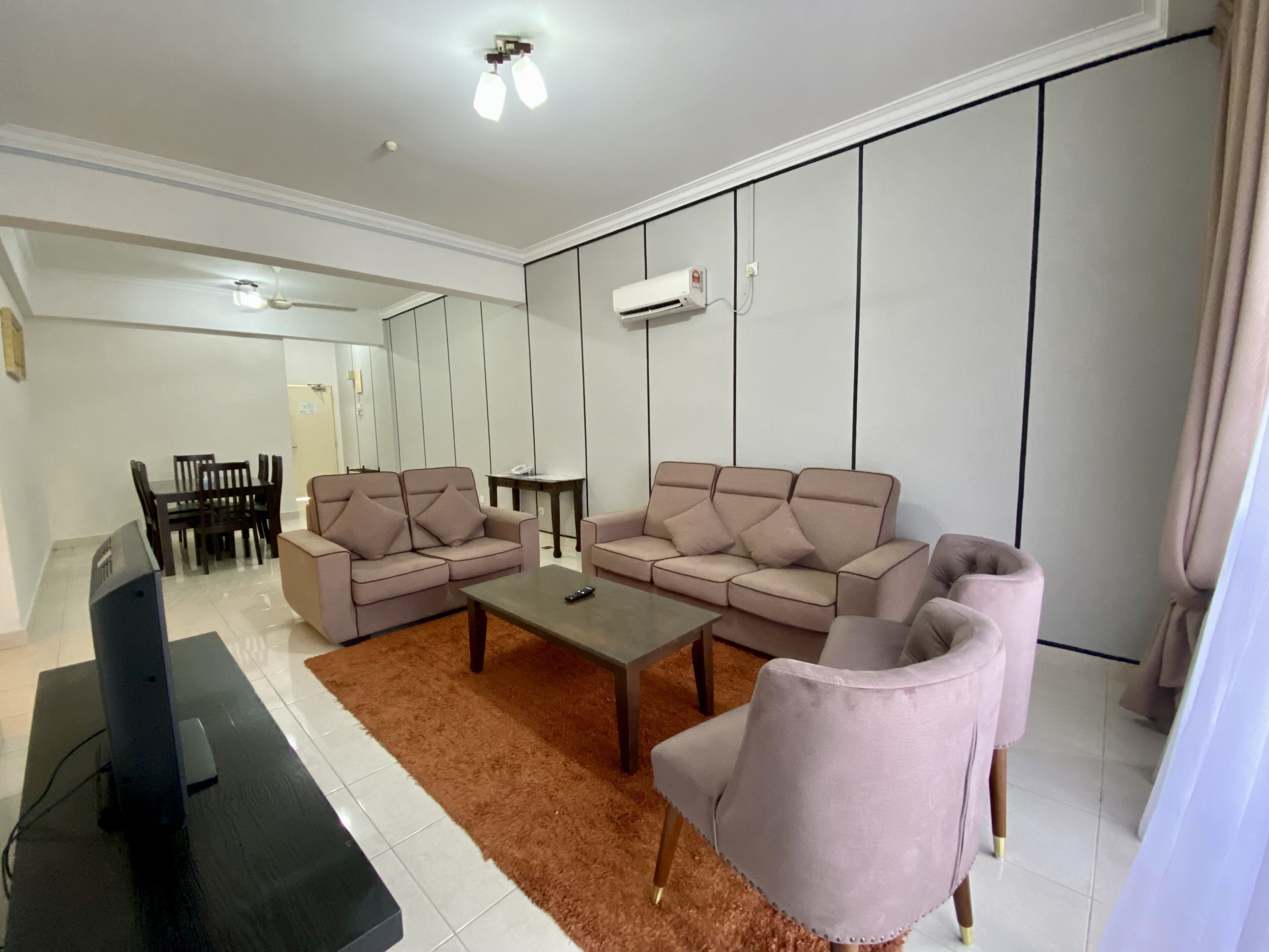 A modern living room with a sofa set, a coffee table, and a TV.