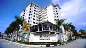 Un edificio de varios pisos con un letrero que dice "SUMAI hotel & apartment".