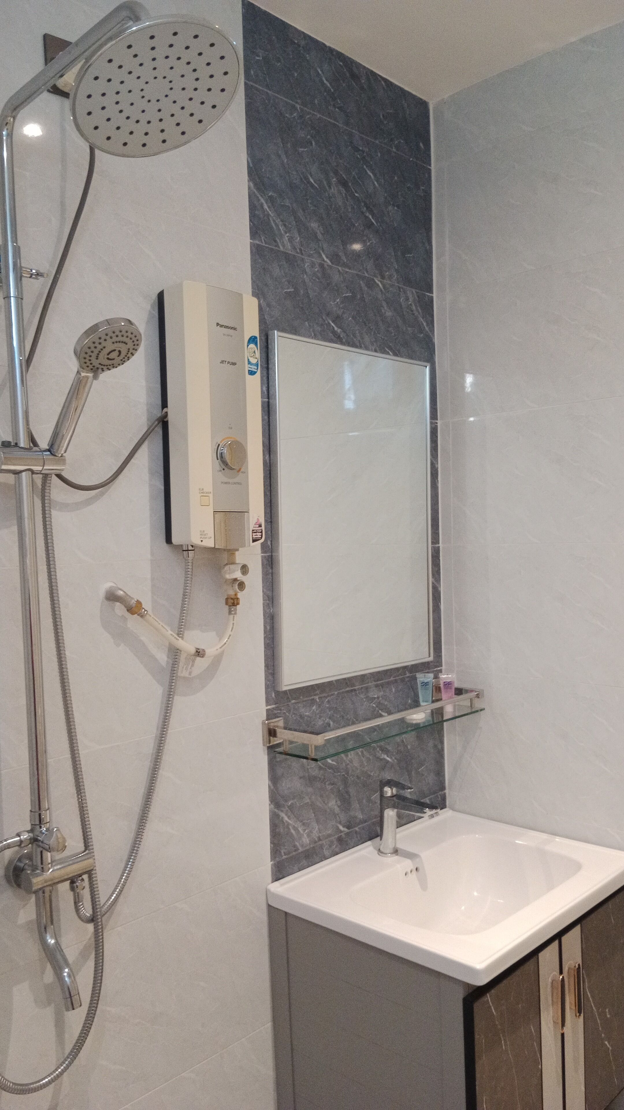 A modern bathroom with a shower, a built-in sink, and a glass shelf.