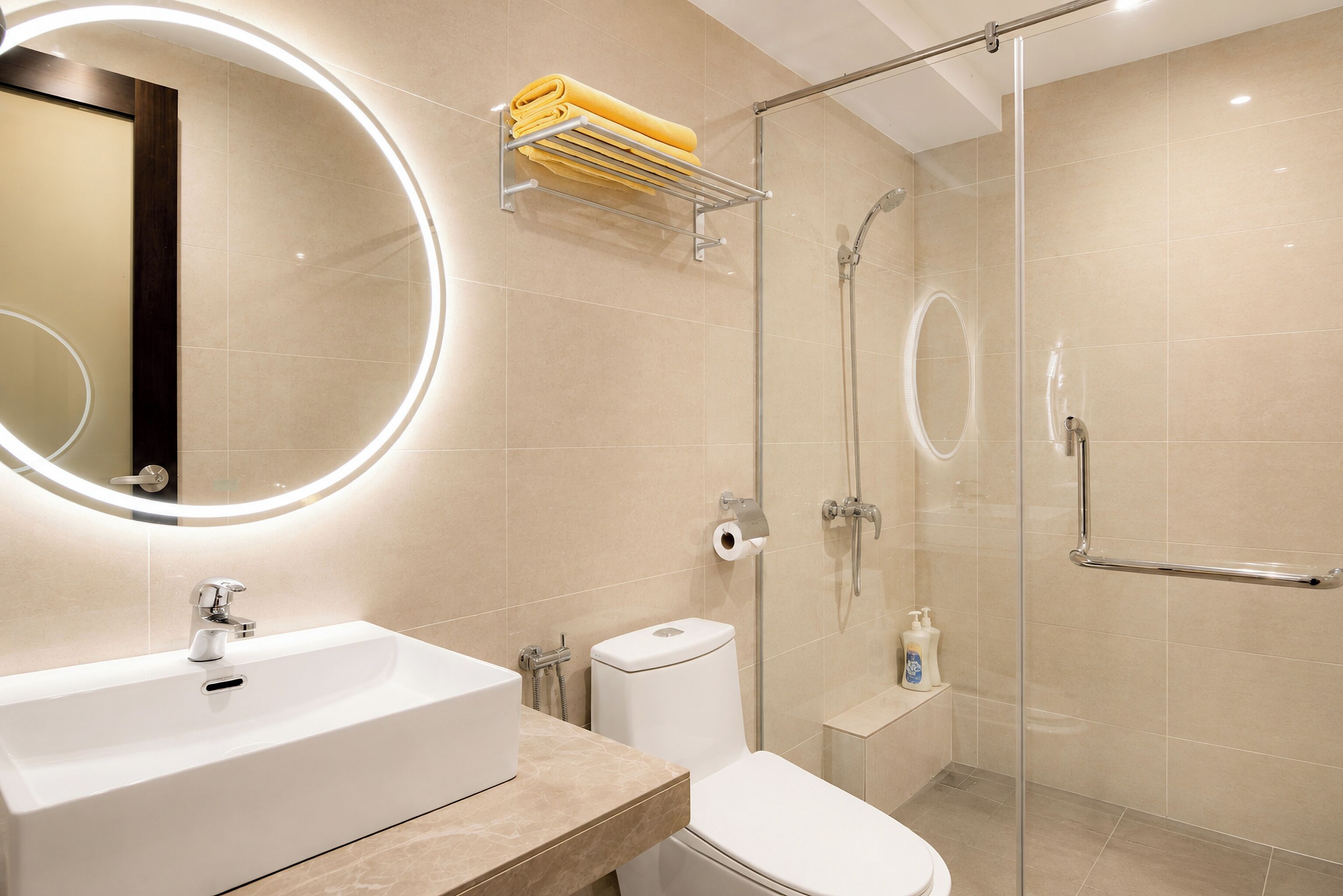 A modern bathroom with a white sink, toilet, and glass-enclosed shower.