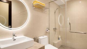 A modern bathroom with a white sink, toilet, and glass-enclosed shower.