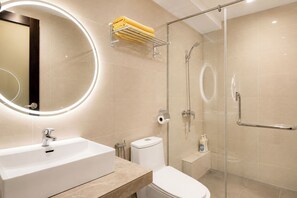 A modern bathroom with a white sink, toilet, and glass-enclosed shower. - Ming Star Hotel (Kuala Terengganu)