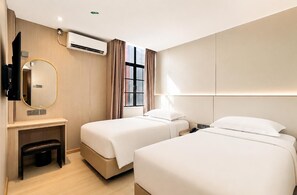A hotel room with two beds, a desk, a chair, a TV, and an air conditioning unit. - Ming Star Hotel (Kuala Terengganu)