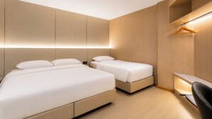 Una habitación de hotel moderna con dos camas, un armario de madera y un escritorio con una silla.