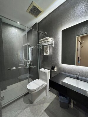 A modern bathroom with a glass-enclosed shower, a toilet, a sink, and a towel rack. - Ming Star Hotel (Kuala Terengganu)
