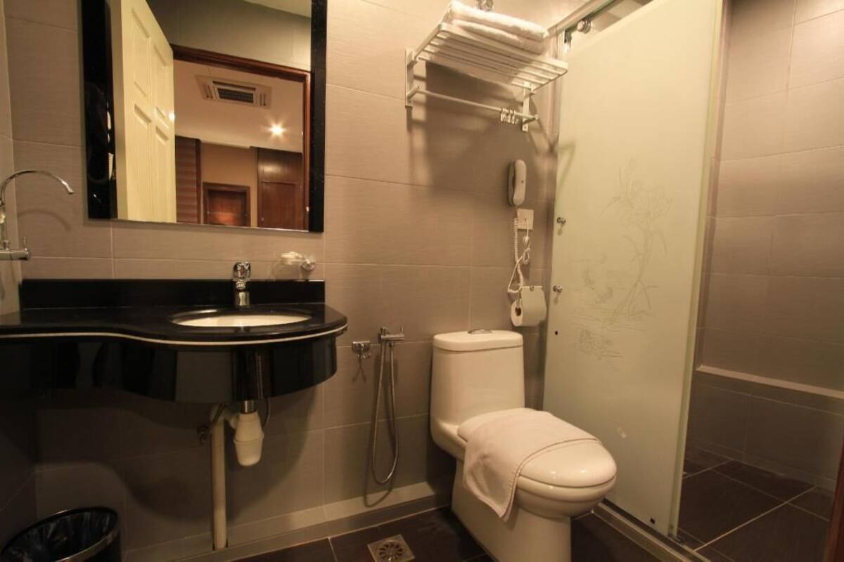 Un baño con lavamanos, inodoro y ducha.
