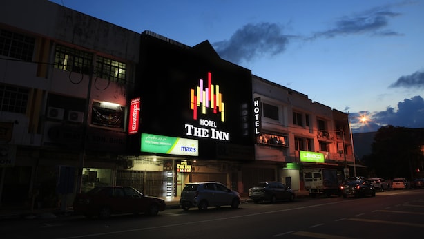 A hotel named "The Inn" with a prominent sign, a visible entrance, and parked cars in front. - The Inn Hotel (Kuala Terengganu)