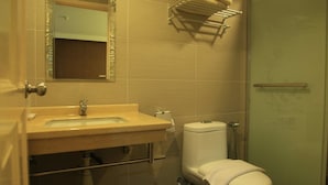A bathroom with a sink, mirror, toilet, and towel rack. - The Inn Hotel (Kuala Terengganu)
