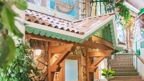 Eine gemütliche Lobby mit Steinwand, Holztreppe, Ledersitzgelegenheiten und einem Holztisch.