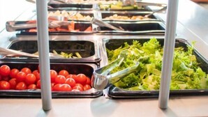 Ein Buffet mit verschiedenen Speisen, darunter Salate, Obst und Gemüse.