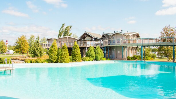 Ein Resort mit großem Schwimmbad, mehreren Gästegebäuden und einem überdachten Gang.