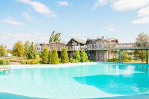 Ein Resort mit großem Schwimmbad, mehreren Gästegebäuden und einem überdachten Gang.