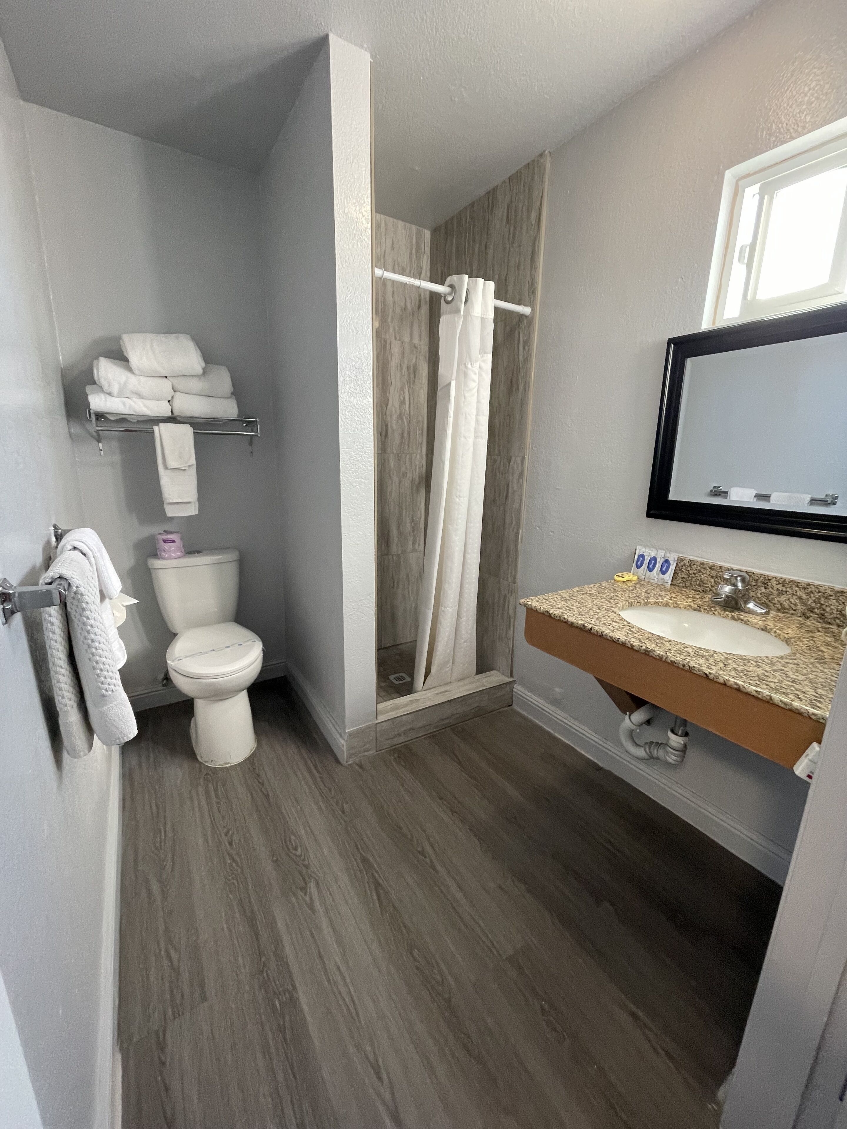Un baño con inodoro, ducha y lavamanos.