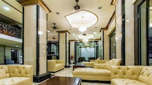 A spacious lobby with a marble floor, leather sofas, and a large wooden coffee table. - Land Royal Residence Pattaya (Pattaya)