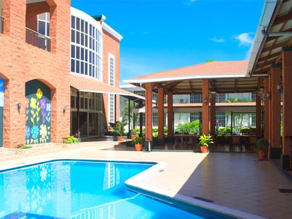 Een buitenzwembad en ligstoelen