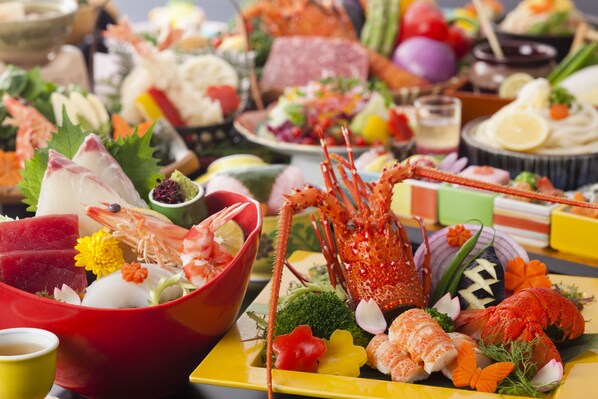 A variety of seafood dishes including shrimp, lobster, and sushi, arranged on a table.