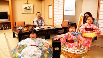 Una habitación japonesa tradicional con suelo de tatami, una mesa baja y un televisor.