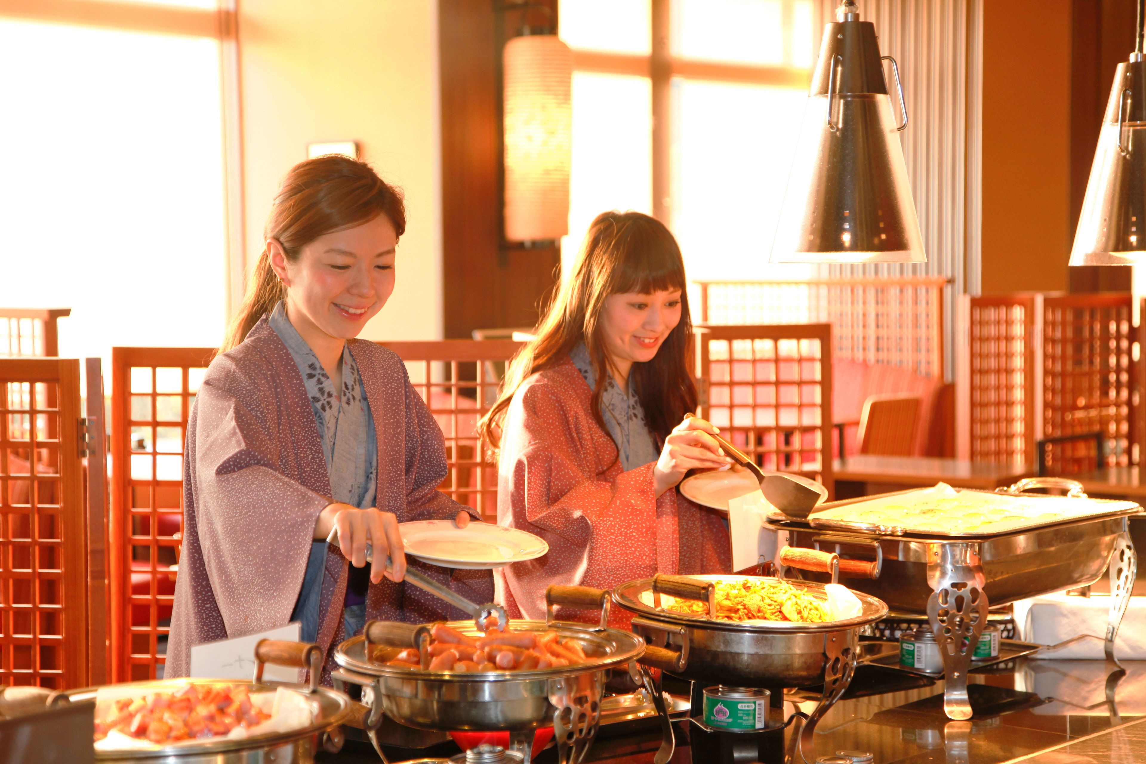 A buffet setup with various dishes and utensils.