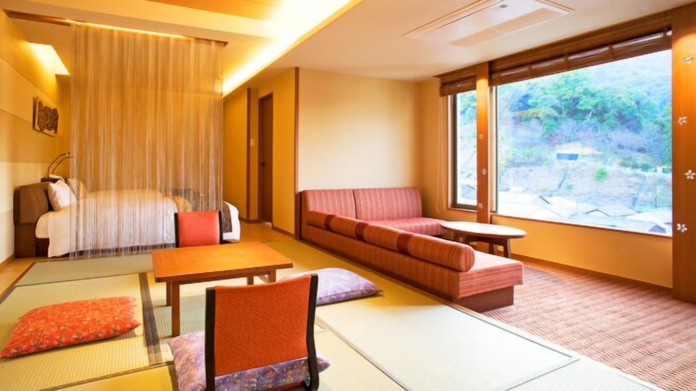 A traditional Japanese-style room with tatami flooring, a low table, a sofa, and a bed with a canopy.