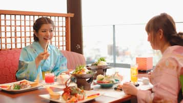 A dining table with various dishes, a beverage, and a traditional Japanese setting.