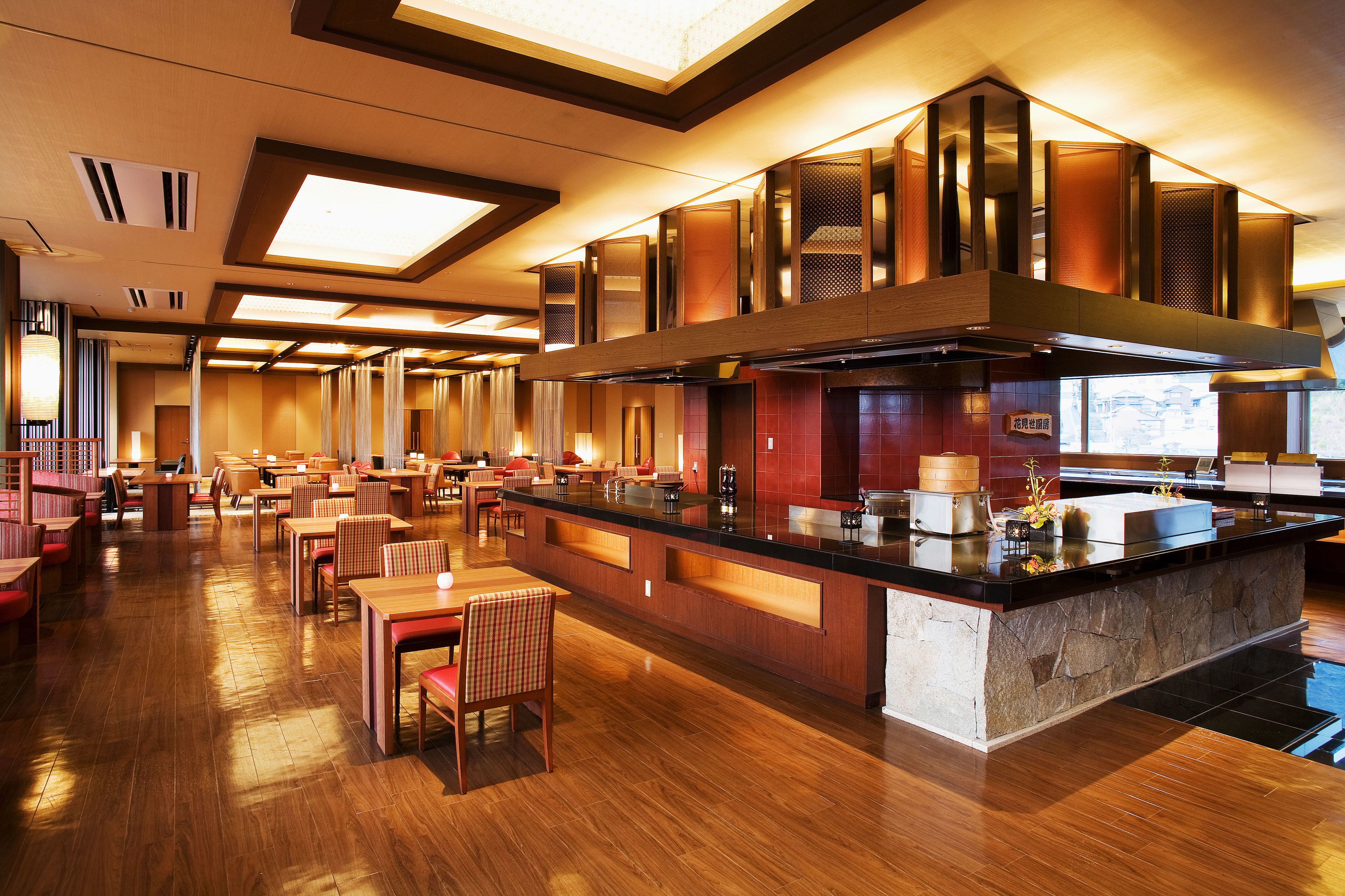 Un restaurante espacioso con una isla central, suelo de madera y un diseño moderno.
