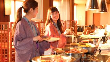 A buffet setup with various food items and a seating area with wooden chairs.