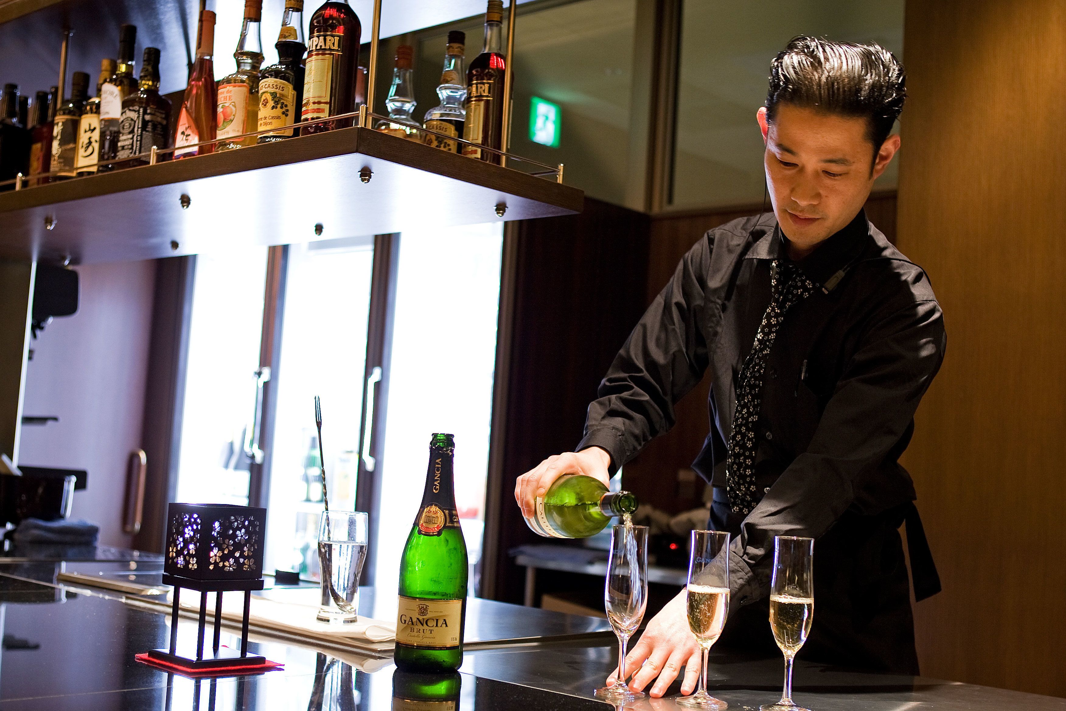 Un barman verse une boisson dans un verre.