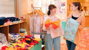 A retail store with shelves of colorful fabrics and a woman holding a patterned bag.