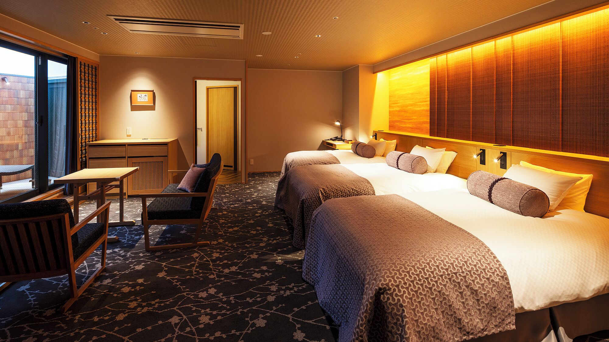 Une chambre d’hôtel avec un lit, un bureau, une chaise et une vue sur l’extérieur.