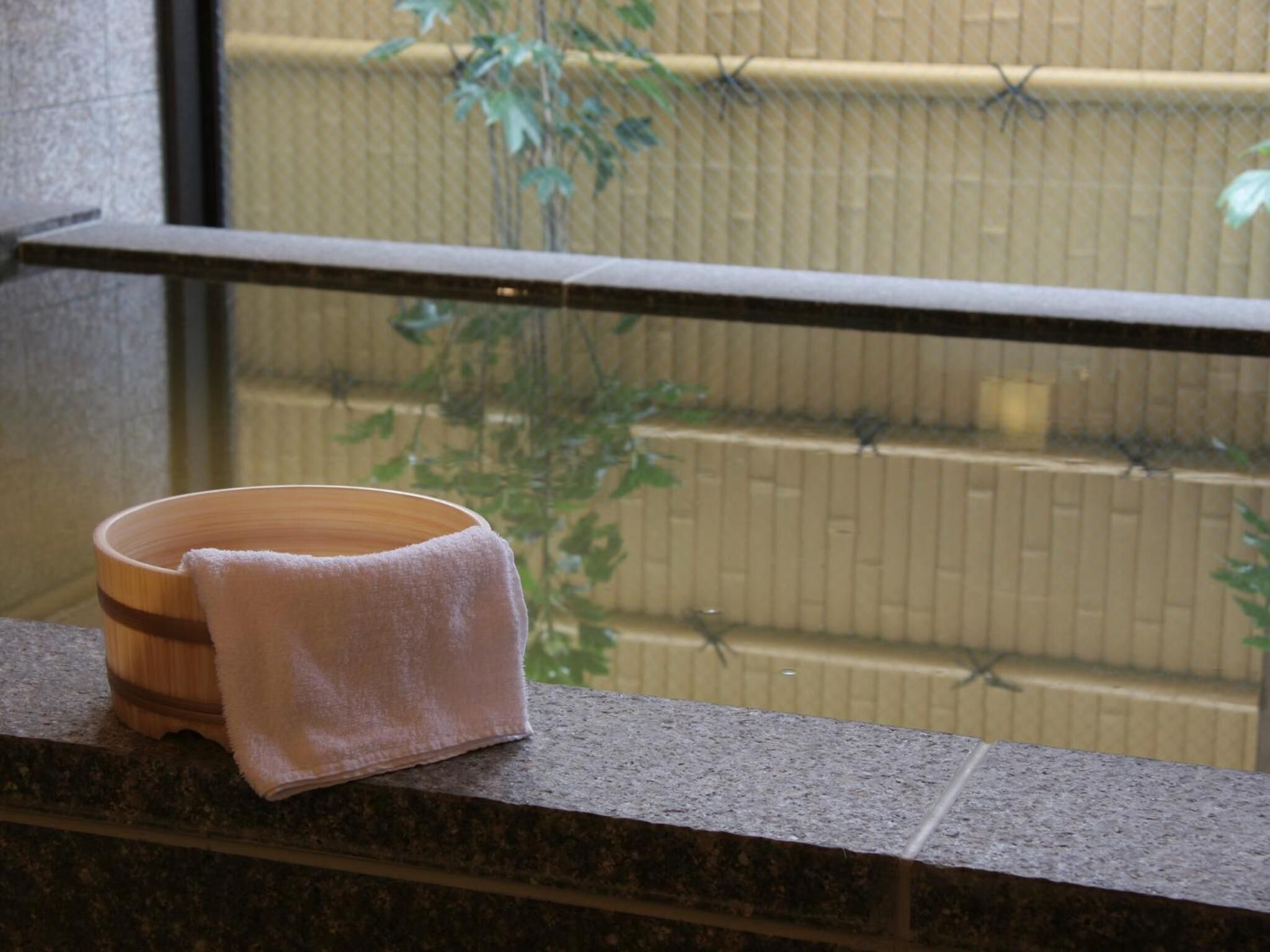 Eine Holtschale mit einem Handtuch auf einer Steinstufe neben einem Fenster.