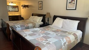 Ett hotellrum med två sängar, ett badrum och en liten sittgrupp.
