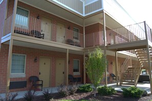 A multi-story building with a brick facade, multiple balconies, and a staircase. - Put in Bay Victory Station Hotel (Put-in-Bay)