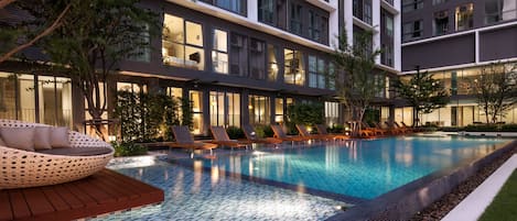 Alberca al aire libre, sombrillas en la alberca y camastros