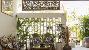 A room with a dining table, chairs, and a decorative wall with plants. - VMANSION Boutique Hotel (Phnom Penh)
