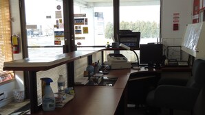 A reception desk with a computer, a printer, and a cash register. There are signs for Visa and MasterCard on the wall. - Star Inn by Elevate Rooms (Niagara Falls)